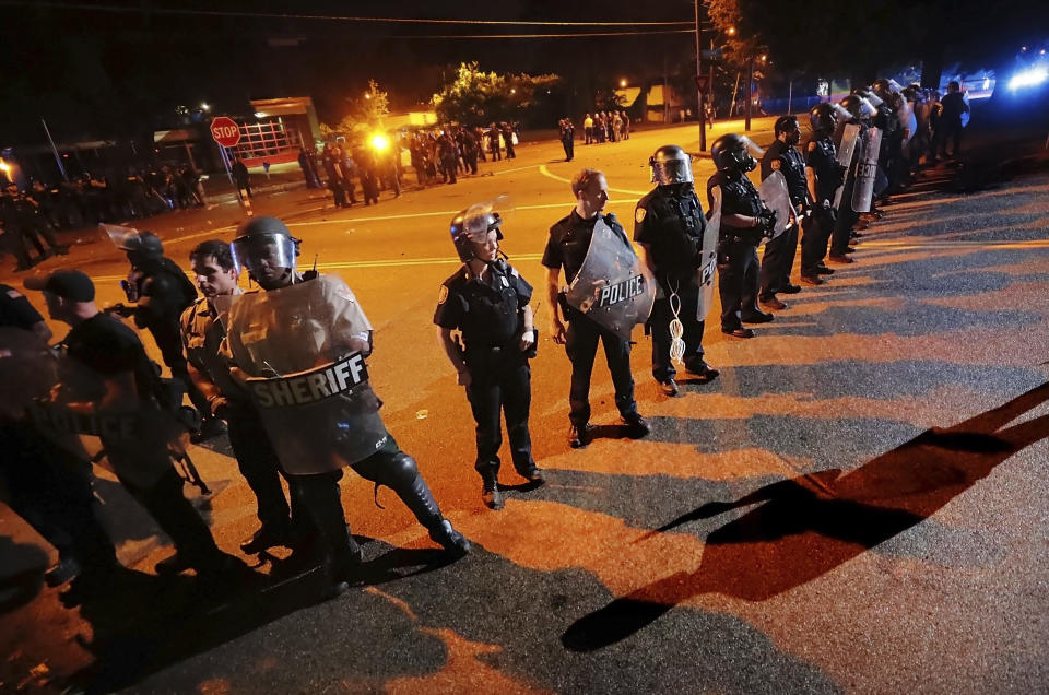 Authorities maintain a perimeter around the crime scene after protesters took to the streets of the Frayser community in anger against the shooting a youth by U.S. Marshals earlier in the evening, Wednesday, June 12, 2019, in Memphis, Tenn. Dozens of protesters clashed with authorities, throwing stones and tree limbs until law enforcement personnel broke up the angry crowd with tear gas. (Jim Weber/Daily Memphian via AP)