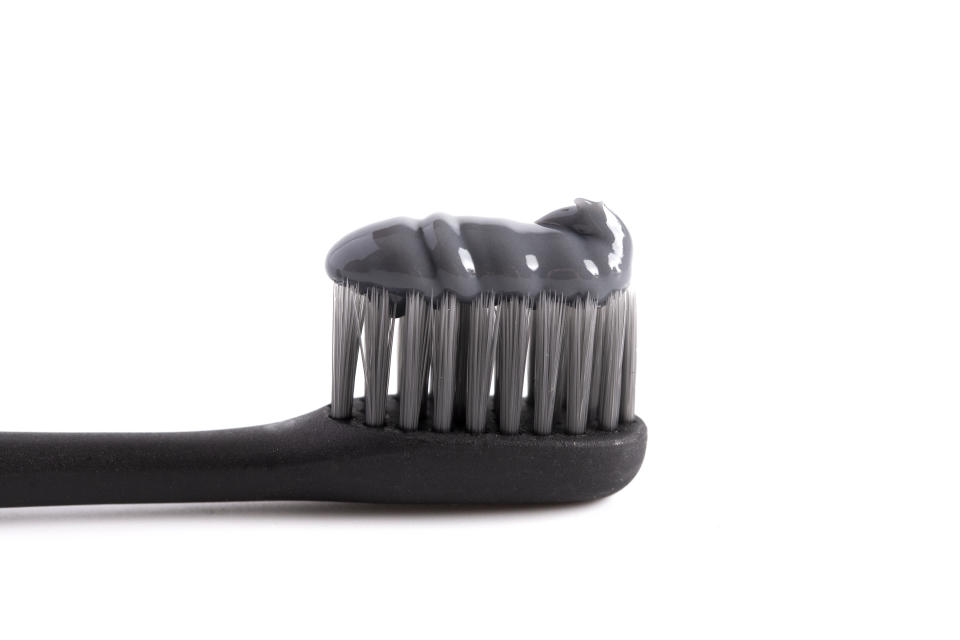 Black Toothbrush with Black Activated Charcoal Toothpaste on a White Background