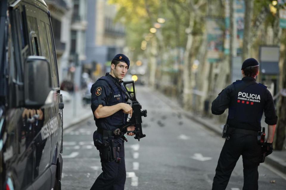 Armed police officers patrol a deserted street in Las Ramblas, in Barcelona, on Friday morning. (AP)