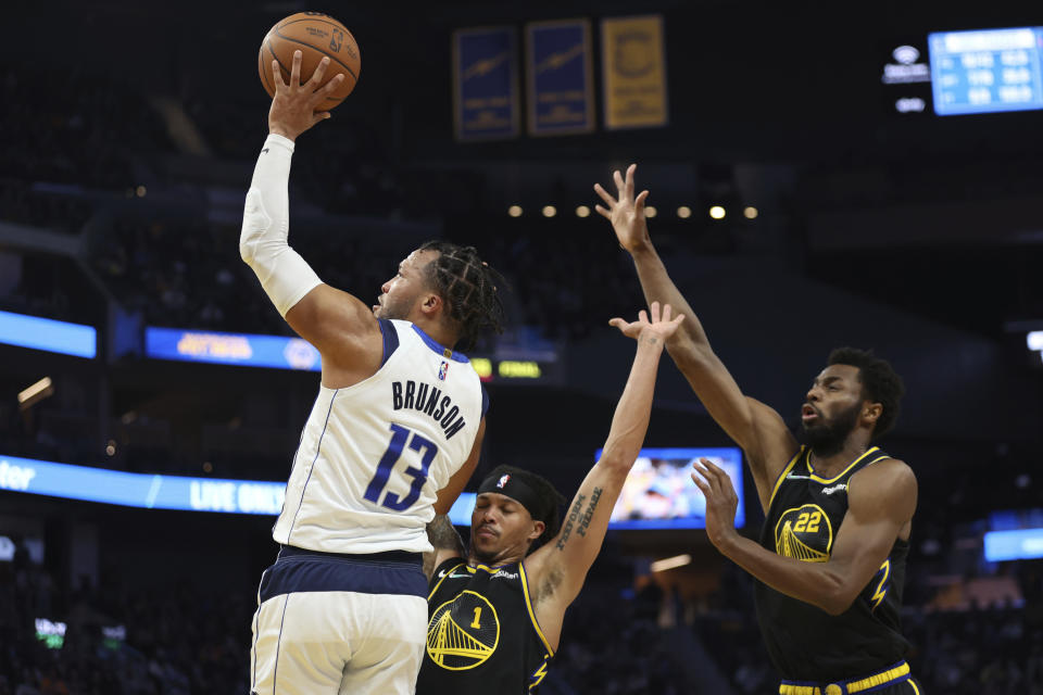 Dallas Mavericks guard Jalen Brunson (13) shoots against Golden State Warriors guard Damion Lee (1) and forward Andrew Wiggins (22) during the first half of an NBA basketball game in San Francisco, Tuesday, Jan. 25, 2022. (AP Photo/Jed Jacobsohn)