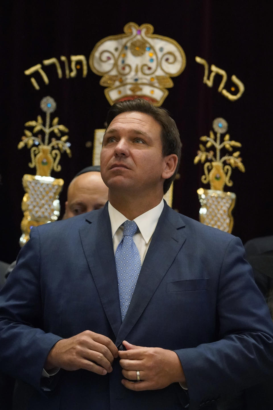 Florida Gov. Ron DeSantis buttons his jacket after speaking, Monday, June 14, 2021, at the Shul of Bal Harbour, a Jewish community center in Surfside, Fla. DeSantis visited the South Florida temple to denounce anti-Semitism and stand with Israel, while signing a bill into law that would require public schools in his state to set aside moments of silence for children to meditate or pray. (AP Photo/Wilfredo Lee)