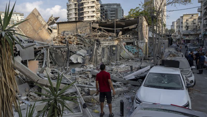 Israelis inspect the rubble of a building a day after it was hit by a rocket fired from the Gaza Strip, in Tel Aviv, Israel, on Sunday, Oct. 8, 2023.