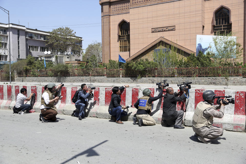 FILE- in this Saturday, April 20, 2019, photo, Afghan journalists work behind a barrier at the site of an attack on the Telecommunication Ministry in Kabul, Afghanistan. Limiting access to information by the Afghan government is not acceptable, said an official form an Afghan watchdog after around 30 media outlets protested severe limitation to information in Afghanistan. (AP Photo/Rahmat Gul, file)