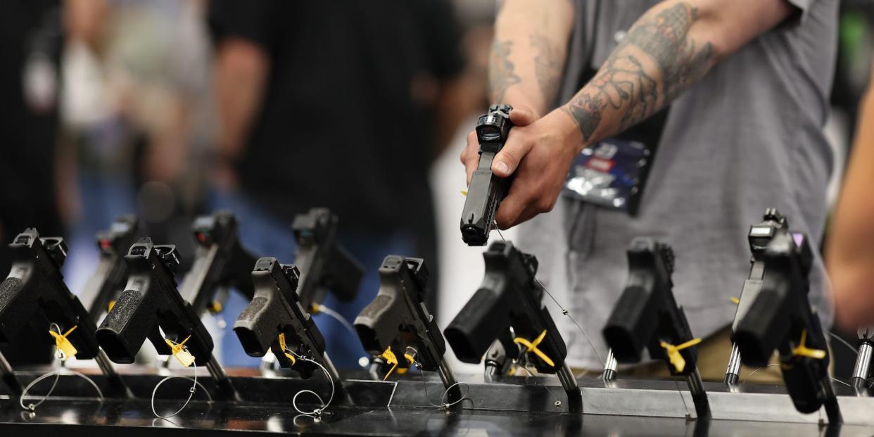 A guest checks out Holosun pistol optics at the National Rifle Association's Annual Meetings & Exhibits at the Indiana Convention Center on April 15, 2023 in Indianapolis, Indiana.