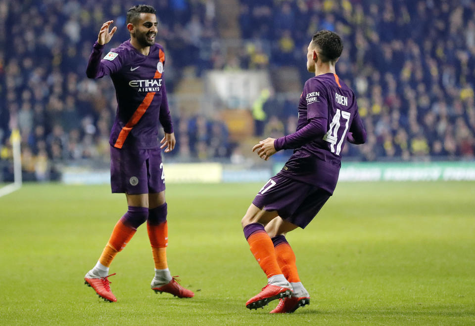 Manchester City's Riyad Mahrez, left, celebrates after scoring his side's second goal during the English League Cup soccer match between Oxford United and Manchester City at the Kassam Stadium in Oxford, England, Tuesday, Sept. 25, 2018. (AP Photo/Frank Augstein)