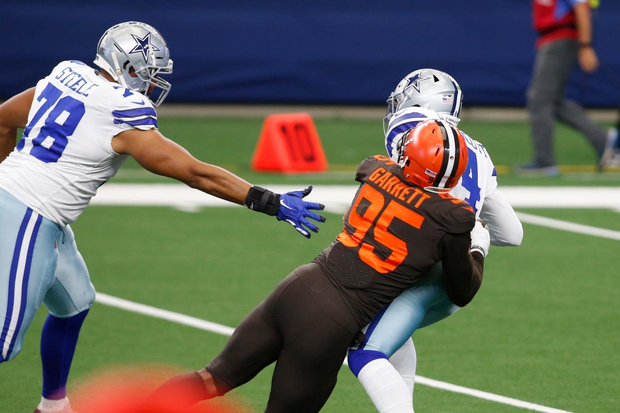 Cowboys quarterback Dak Prescott is sacked by Browns defensive end Myles Garrett in the first quarter, Oct. 4, 2020, in Arlington, Texas.