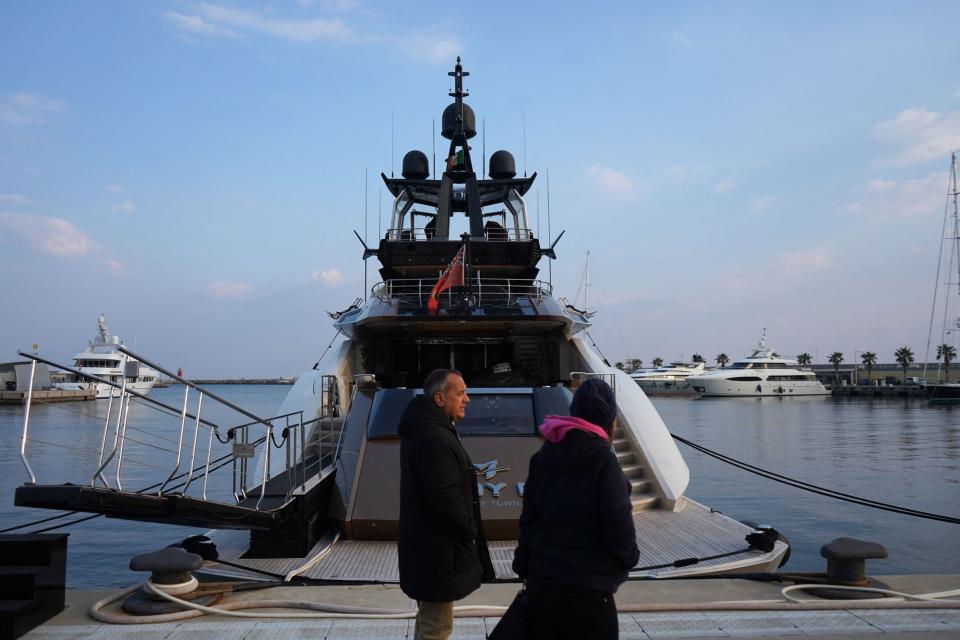 Pedestrians walk past the yacht "Lady M," owned by Russian oligarch Alexei Mordashov, docked at Imperia's harbor on March 5, when Italian police seized the yacht after the European Union targeted Mordashov and other Kremlin-linked oligarchs following Moscow's invasion of Ukraine. (Photo by ANDREA BERNARDI/AFP via Getty Images)