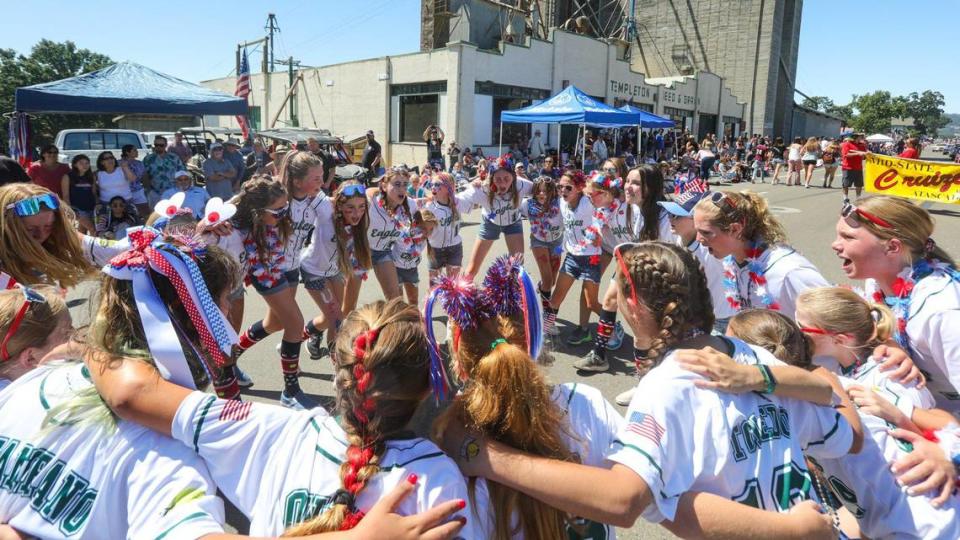 The Templeton U-12 and U-10 girl’s softball all-star teams cheer before handing out cold water to the crowd during the Templeton 4th of July Parade on Tuesday, July 4, 2023.