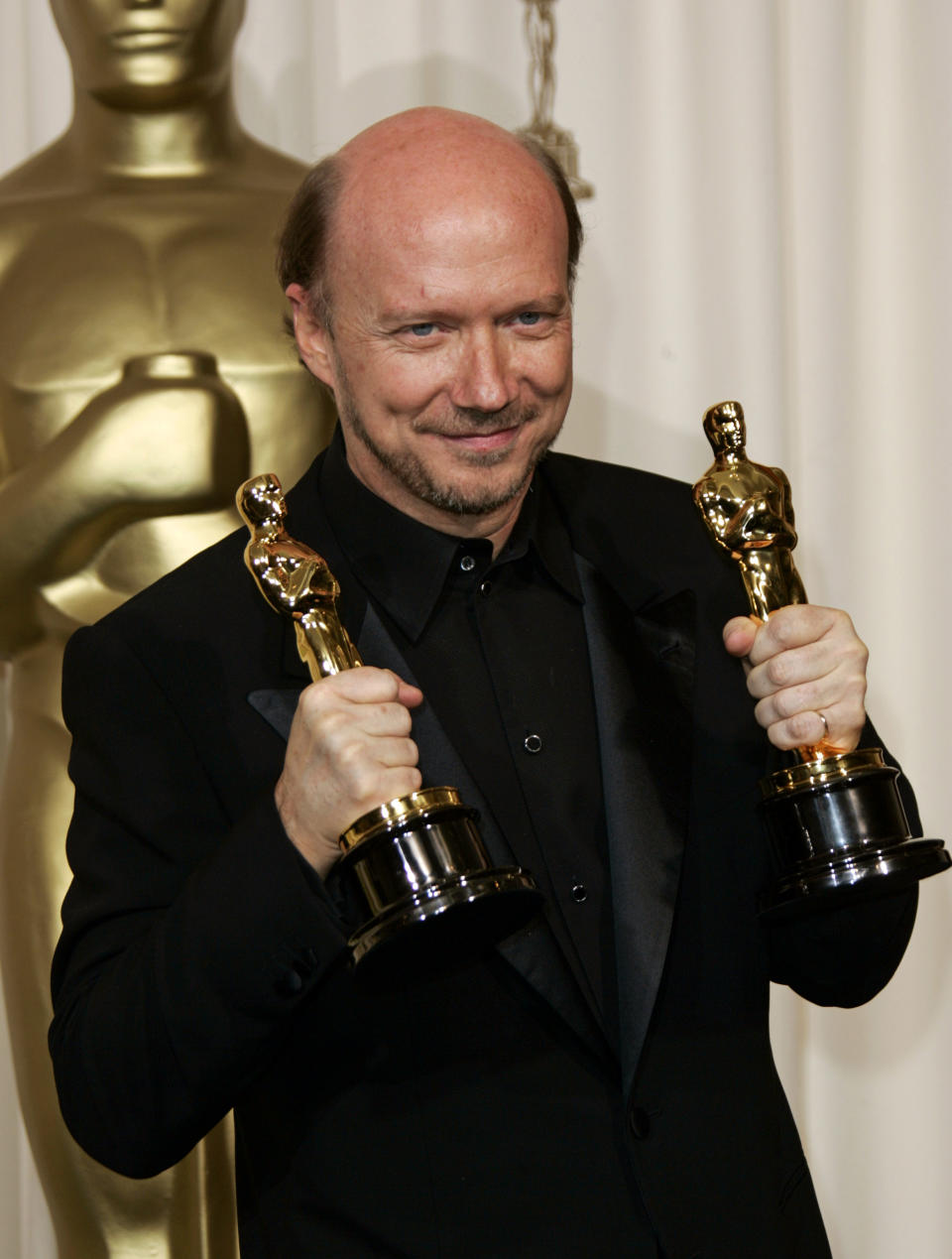 Director Paul Haggis poses with the two Oscars he won for best motion picture of the year and best original screenplay at the 78th Academy Awards Sunday, March 5, 2006, in Los Angeles. (AP Photo/Kevork Djansezian)