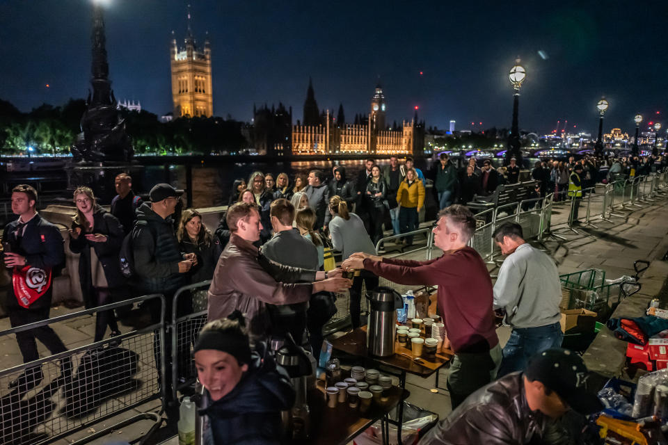 A group of friends hand out hot drinks to people waiting in the queue on Saturday, Sept. 17, 2022, in London, England. The queue of people waiting to pay their respects to Queen Elizabeth II as she lies in state has stretched for miles. (Anthony Devlin / Getty Images)