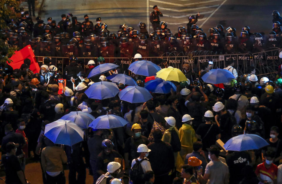 Pro-democracy activists confront a police blockage during their march to the Government House, prime minister's office during a protest march in Bangkok, Thailand, Wednesday, Oct. 21, 2020. Thailand's prime minister on Wednesday pleaded with his countrymen to resolve their political differences through Parliament, as student-led protests seeking to bring his government down continued for an eighth straight day. (AP Photo/Sakchai Lalit)