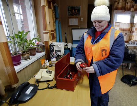 Elena Kachalina, whose job is to supervise a crossing point at Saltykovskaya station, works in the Moscow suburb of Balashikha December 22, 2014. REUTERS/Tatyana Makeyeva