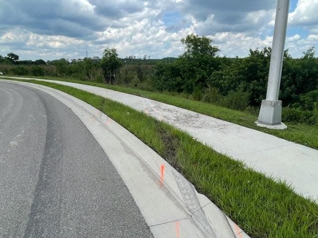 Skid marks mark a path along Topgolf Way in Fort Myers after five people, at least four of them workers at nearby Texas Roadhouse, crashed late Sunday, June 25, 2023. The black Kia sedan went into a retention pond, killing them.