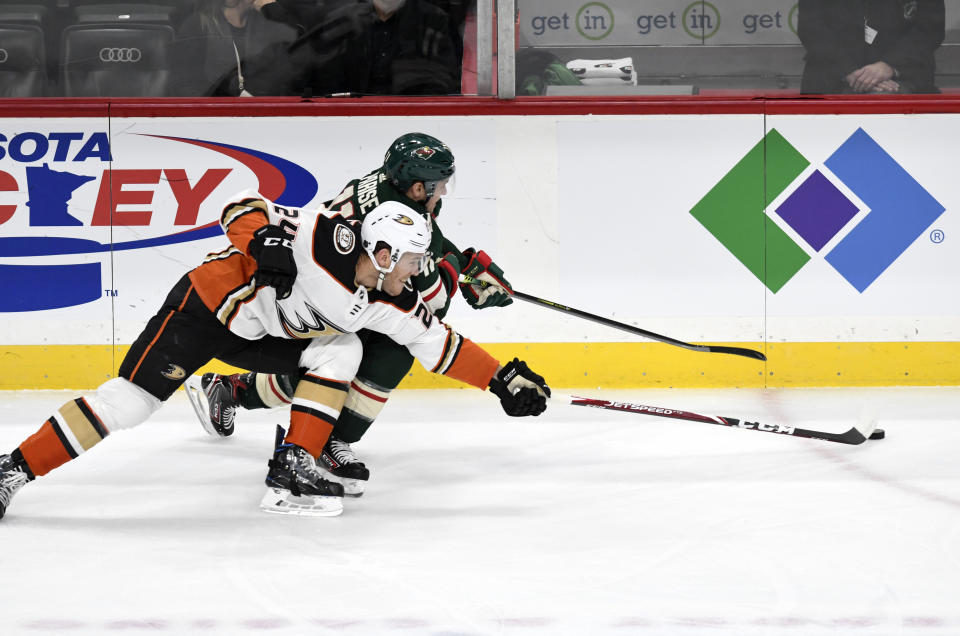 Minnesota Wild's Zach Parise, back, and Anaheim Ducks' Carter Rowney, front, go after the puck in the first period of an NHL hockey game, Tuesday, Dec. 10, 2019, in St. Paul, Minn. (AP Photo/Tom Olmscheid)