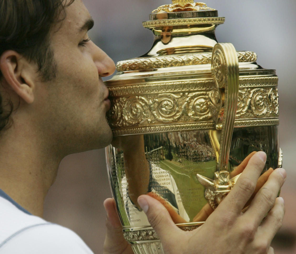 FILE - Roger Federer of Switzerland, kisses the winners' trophy after defeating Andy Roddick 6-2, 7-6 (2), 6-4 in the Mens' Singles Final on Centre Court at Wimbledon Sunday, July 3, 2005. Federer announced Thursday, Sept.15, 2022 he is retiring from tennis. (AP Photo/Alastair Grant, File)