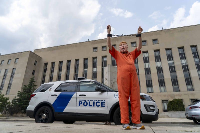 A demonstrator dressed as former President Donald Trump stands in fake handcuffs outside the E. Barrett Prettyman Federal Courthouse in Washington on Wednesday. Photo by Bonnie Cash/UPI