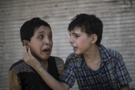 <p>Zeid Ali, 12, left, and Hodayfa Ali, 11, comfort each other after their house was hit and collapsed during fighting between Iraqi forces and Islamic State militants in Mosul, Iraq, Saturday, June 24, 2017. The Ali cousins said some of their family members are still under the rubble. (Photo: Felipe Dana/AP) </p>