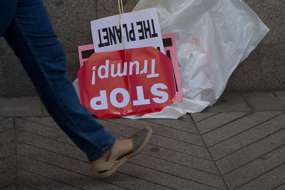 A woman walks past a discarded ‘Stop Trump’ banner in Madrid