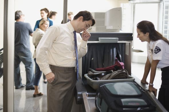 Businessman and security officer at airport security checkpoint