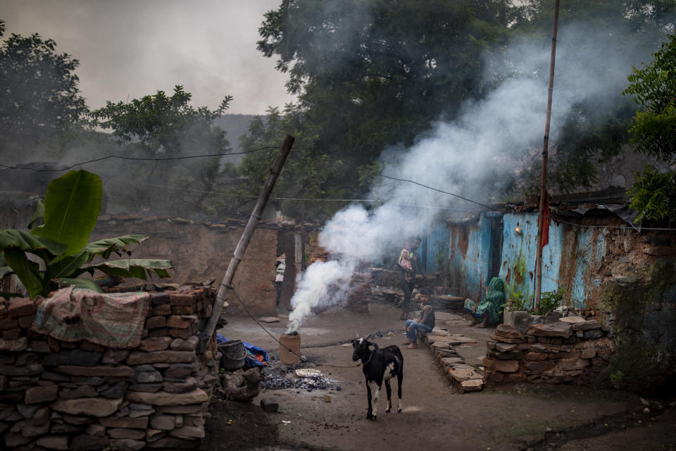 Smoke emits from a coal stove in the compound of a house in a village in the eastern Indian state of Jharkhand where a community of coal scavengers live and work, Friday, Sept. 24, 2021. On Saturday, India asked for a crucial last minute-change to the final agreement at crucial climate talks in Glasgow, calling for the "phase-down" not the "phase-out" of coal power. (AP Photo/Altaf Qadri)