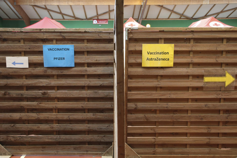 Signs at a vaccination center show directions to follow to get the AstraZeneca or the Pfizer vaccine, in a vaccination center of Saint-Jean-de-Luz, southwestern France, Tuesday, March 16, 2021. With coronavirus cases rising in many places, governments faced the grimmest of dilemmas Tuesday: push on with a vaccine that is known to save lives or suspend use of AstraZeneca over reports of dangerous blood clots in a few recipients, even as the European regulator said there was "no indication" the shot was responsible. (AP Photo/Bob Edme)