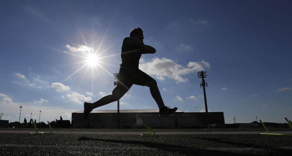 A student athlete runs a drill during a strength and conditioning camp at Arlington Martin High School Thursday, June 18, 2020, in Arlington, Texas. While states have been easing the economic and social lockdowns prompted by the coronavirus pandemic, some are now letting high school athletes return for summer workouts before teachers have even figured out how they are going to hold classroom instruction. (AP Photo/LM Otero)