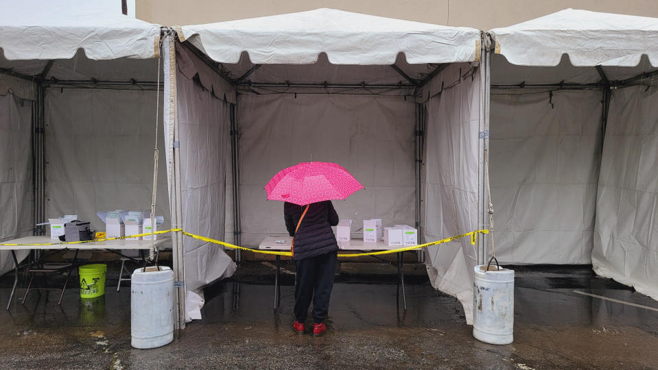 People stand in line under the rain for a free COVID-19 test outside the Lincoln Park Recreation Center in Los Angeles on Thursday, Dec. 30, 2021. More than a year after the vaccine was rolled out, new cases of COVID-19 in the U.S. have soared to their highest level on record at over 265,000 per day on average, a surge driven largely by the highly contagious omicron variant. (AP Photo/Damian Dovarganes)