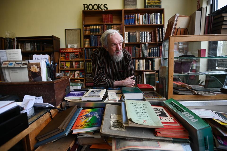 Ray Walsh, 75, owner of the Archives Book Shop and Curious Book Shop, both in East Lansing, poses for a portrait at the Archives Book Shop, Monday, Feb. 5, 2024. He plans to close Archives at the end of the month.