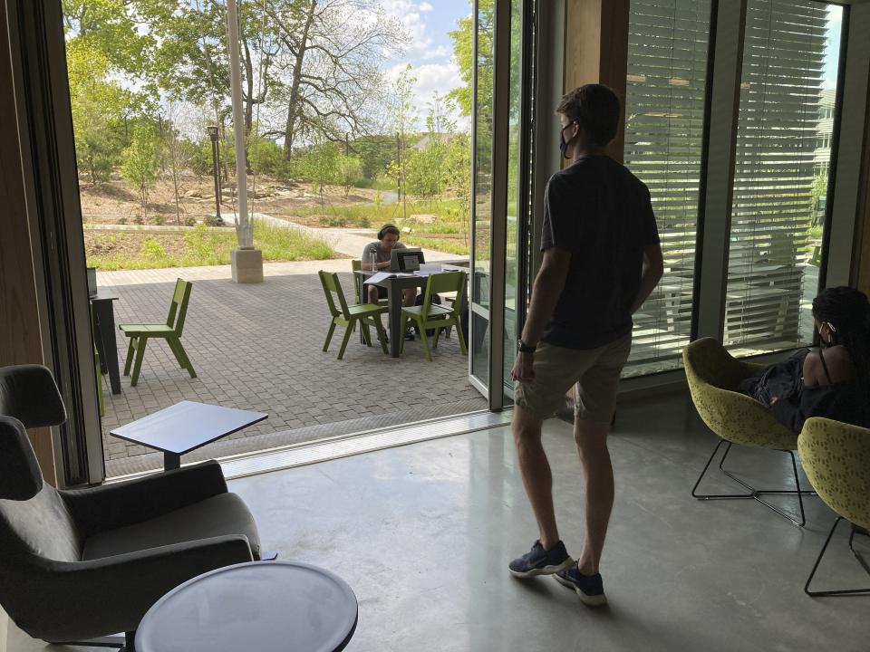 A student walks outside at Georgia Tech's Kendeda Building on Tuesday, April 20, 2021, in Atlanta. The $25 million structure has been certified as a living building, meaning it helps the environment more than it hurts it. (AP Photo/Jeff Amy)