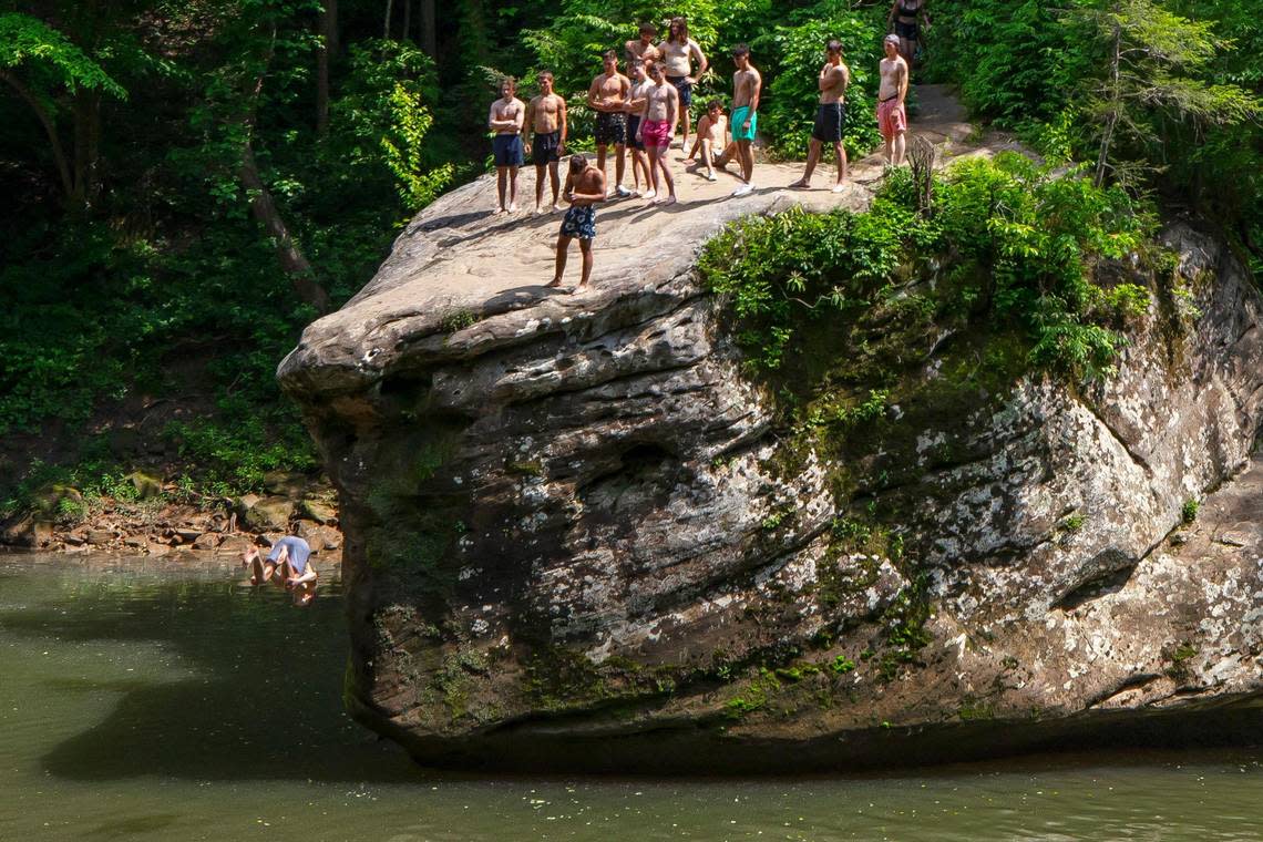 People jump off a rock into the Red River near the Sheltowee Trace trail in the Daniel Boone National Forest near Slade, Ky., on Monday, May 30, 2022.