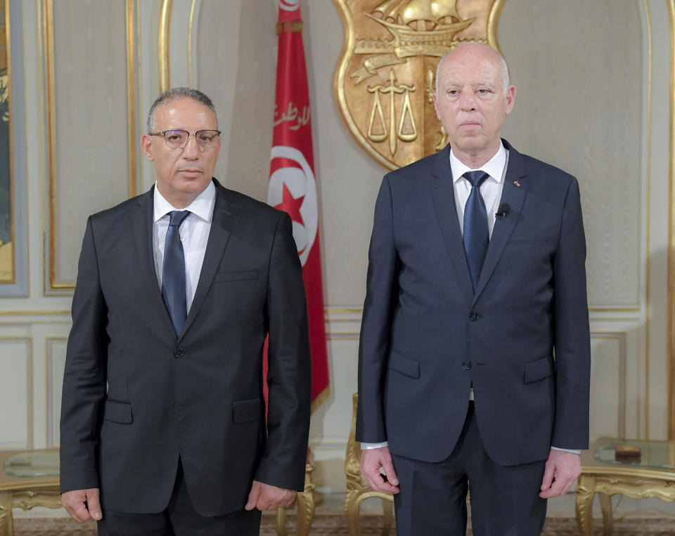 New acting Tunisian Interior Minister Ridha Gharsallaoui , left, and Tunisian President Kais Saiedis poses after a sworn in ceremony at the Presidential Palace in Carthage, outside Tunis, Tunisia, Thursday, July 29, 2021. Tunisian President Kais Saied on Thursday appointed Ridha Gharsallaoui, a former national security adviser to the presidency, to run the Interior Ministry. (Slim Abid/Tunisian Presidency via AP)