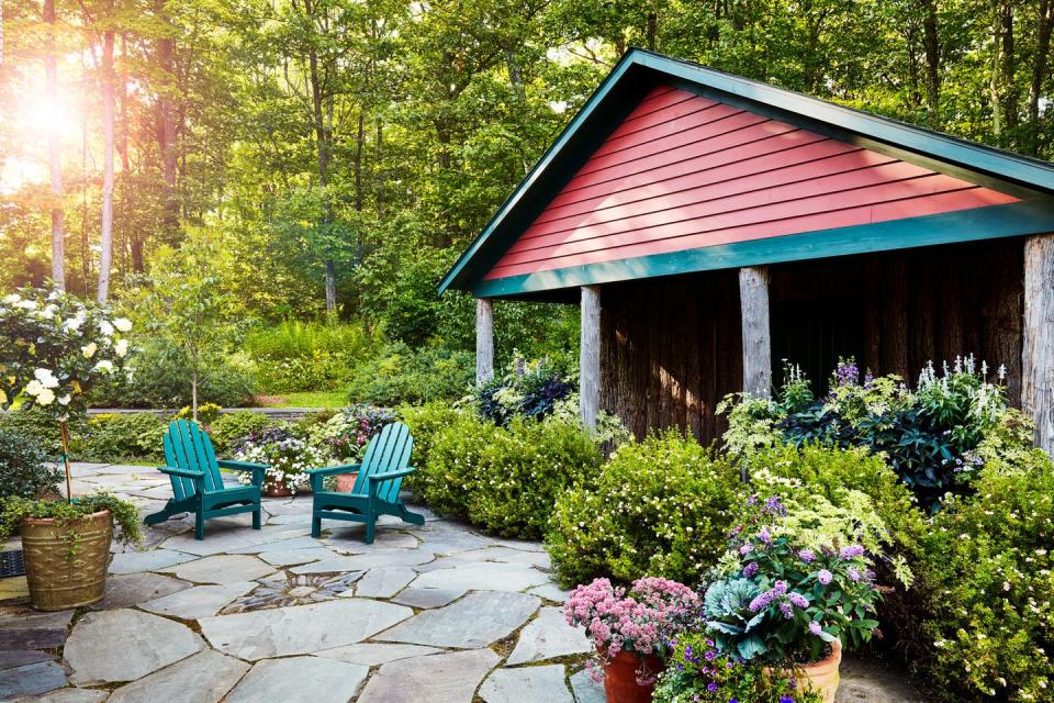 a small patio with chairs and a small house with a red roof