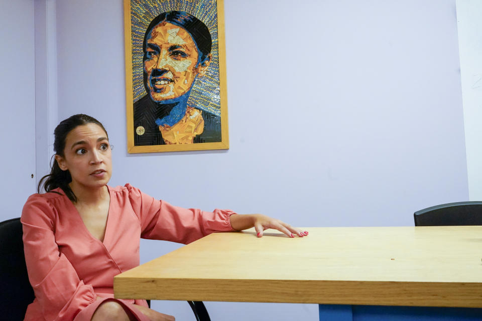 A employee, right, works in her office as Rep. Alexandria Ocasio-Cortez, D-N.Y., speaks during an interview to The Associated Press at her office in the Jackson Heights neighborhood of the Queens borough of New York, Wednesday, July 6, 2022. As she seeks a third term this year and navigates the implications of being celebrity in her own right, she's determined to avoid any suggestion that she is losing touch with her constituents. (AP Photo/Mary Altaffer)