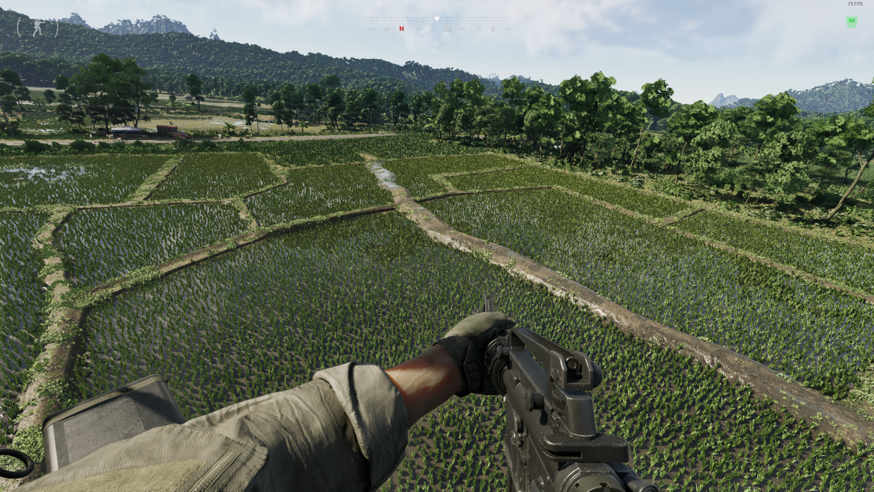  A screenshot from Gray Zone Warfare, showing the player flying over the top of waterlogged fields in a helicopter. 