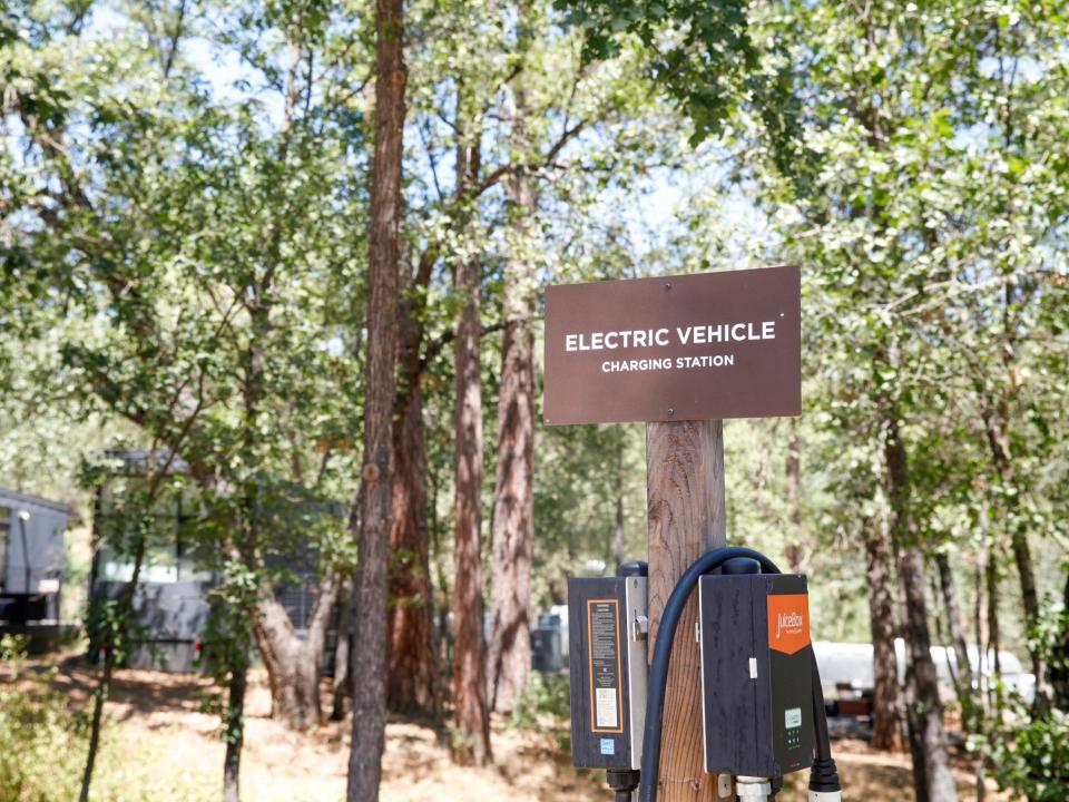 electric vehicle charging stations in front of cabins and trees