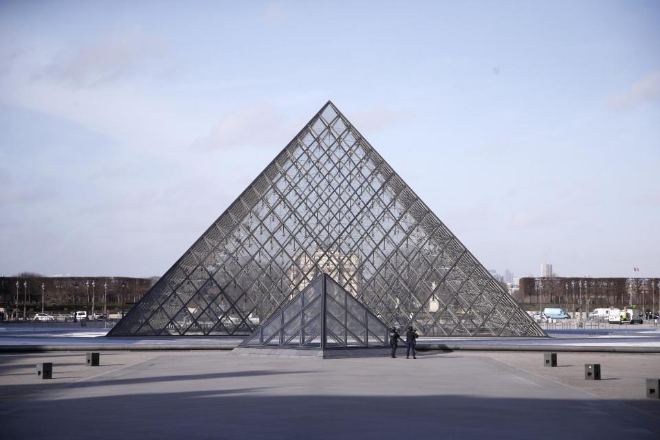 Police officers patrol at the pyramid outside the Louvre museum in Paris,Friday, Feb. 3, 2017. Paris police say a soldier has opened fire outside the Louvre Museum after he was attacked by someone, and the area is being evacuated. (AP Photo/Thibault Camus)