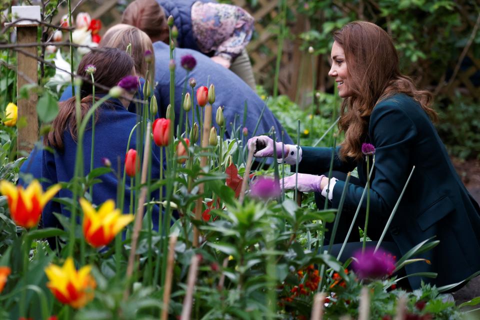 Britain's Catherine, Duchess of Cambridge plants sunflower seeds with volunteers as she visits Starbank Park to hear about the work of Fields in Trust, along with Britain's Prince William, Duke of Cambridge, in Edinburgh, Scotland on May 27, 2021. (Photo by PHIL NOBLE / POOL / AFP) (Photo by PHIL NOBLE/POOL/AFP via Getty Images)