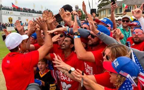 USA team member and captain Tiger Woods (L) celebrates with fans after his team won the Presidents Cup golf tournament in Melbourne on December 15, 2019 - Credit: Getty Images