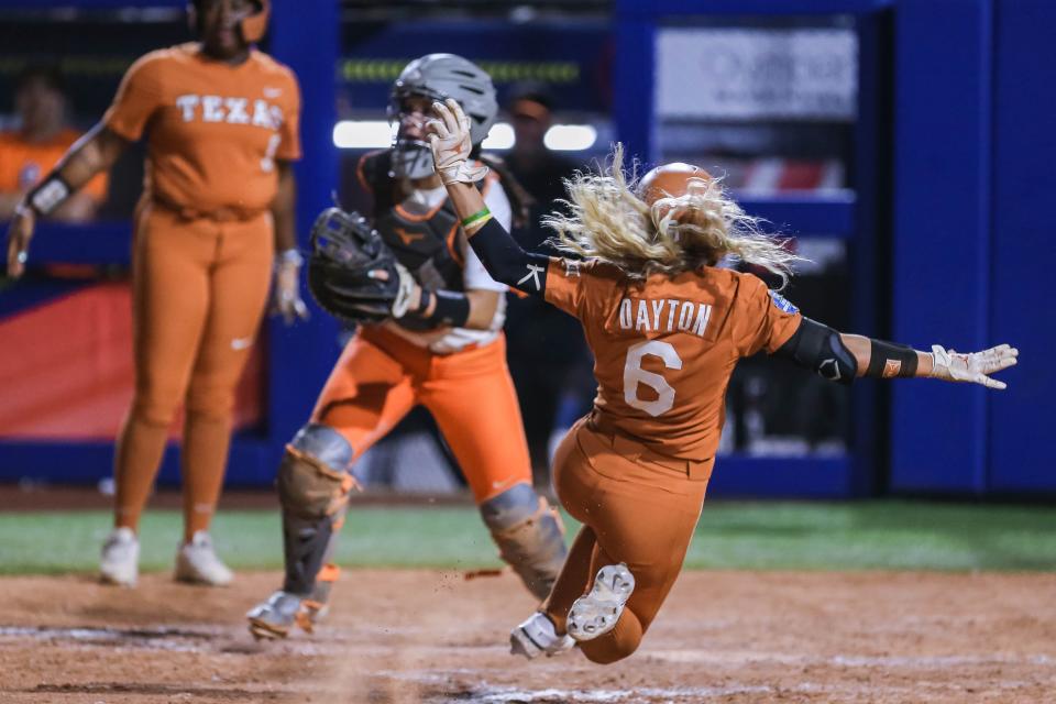 Texas outfielder Bella Dayton (6) slides home for a run in a 6-5 win against OSU in the second WCWS semifinal Monday night.