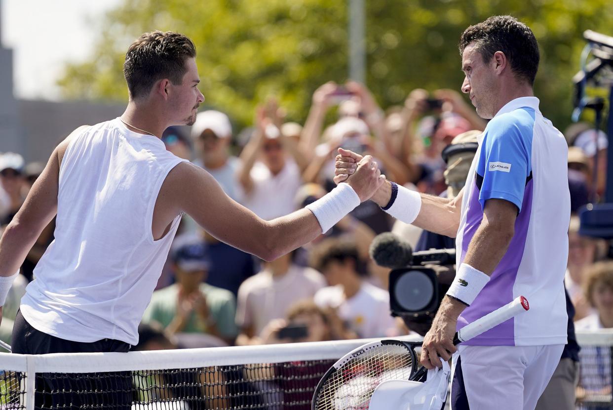 J.J. Wolf, of the United States, shakes hands with Roberto Bautista Agut, of Spain, during the first round of the U.S. Open tennis championships, Monday, Aug. 29, 2022, in New York.