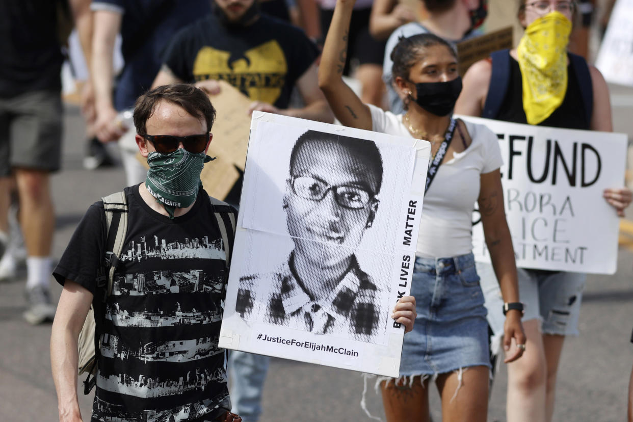 A demonstrator carries an image of Elijah McClain (David Zalubowski / AP file)