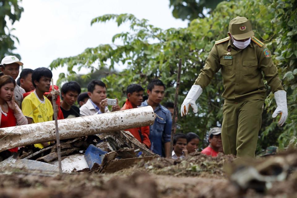 Villagers gather as rescue personnel work at the crash site of an ATR-72 turboprop plane, in Laos, near Pakse