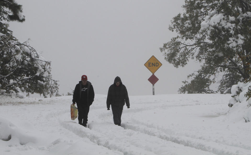 Chris Gilbert, left, and SebastianDrew, walk through the snow after sledding near Blue Canyon, Calif, Monday, Oct. 22, 2012. The first storm of the season swept through Northern California bringing rain to the lower elevations and snow in the mountains. (AP Photo/Rich Pedroncelli)