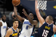 Orlando Magic guard Dwayne Bacon (8) drives to the rim as Denver Nuggets center Nikola Jokic (15) defends in the first half of an NBA basketball game, Sunday, April 4, 2021, in Denver. (AP Photo/David Zalubowski)