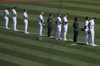 Oakland Athletics players and staff observe a moment of silence for Supreme Court Justice Ruth Bader Ginsburg before a baseball game against the San Francisco Giants in Oakland, Calif., Saturday, Sept. 19, 2020. (AP Photo/Jeff Chiu)