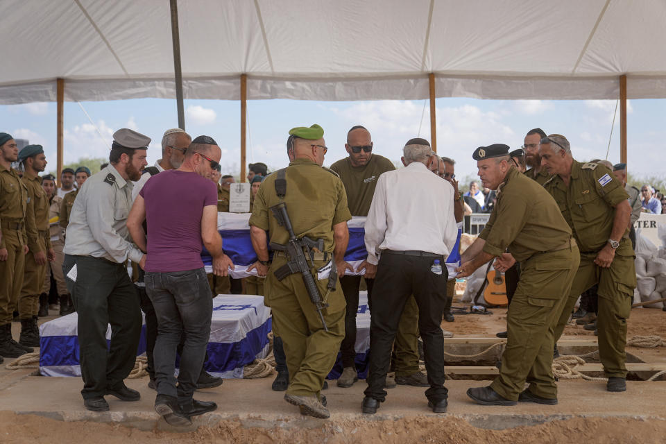 Mourners carry the five coffins of the Kotz family during their funeral in Gan Yavne, Israel, Tuesday, Oct. 17, 2023. The family was killed by Hamas militants on Oct. 7 at their house in Kibbutz Kfar Azza near the border with the Gaza Strip, More than 1,400 people were killed and some 200 captured in an unprecedented, multi-front attack by the militant group that rules Gaza. (AP Photo/Ohad Zwigenberg)