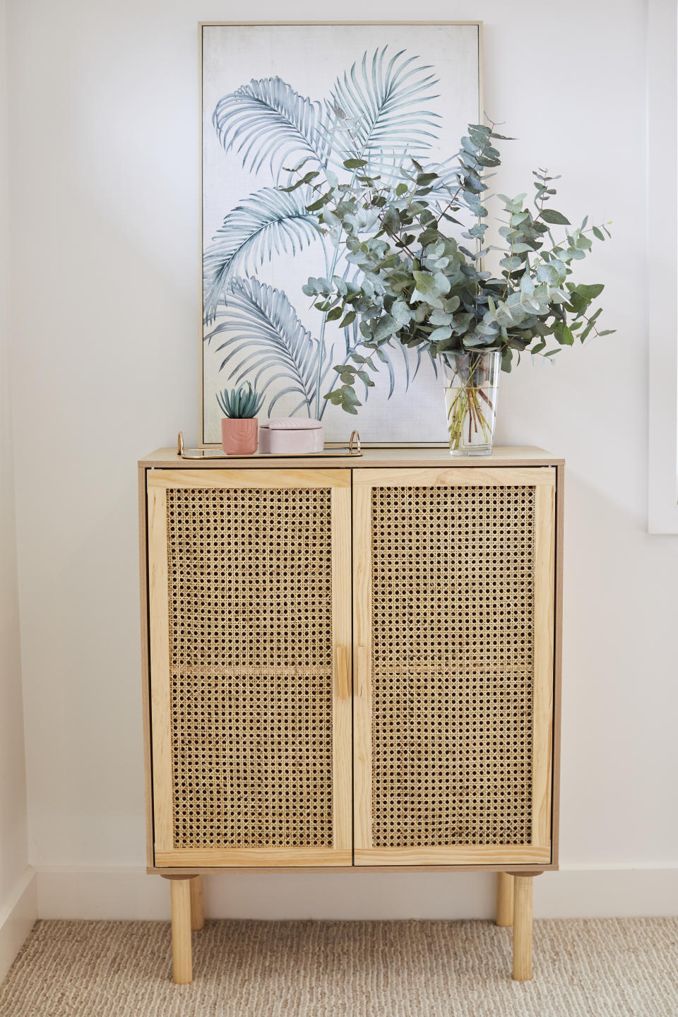 Kmart August Living Rattan cabinet $85, Palm framed print $19.