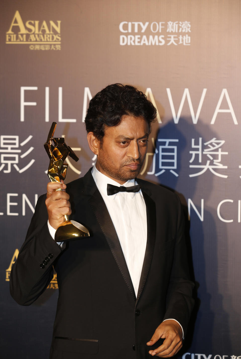 Indian actor Irrfan Khan celebrates after winning the Best Actor for his movie "The Lunchbox" of the Asian Film Awards in Macau Thursday, March 27, 2014. (AP Photo/Kin Cheung)