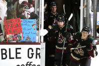 Arizona Coyotes' Logan Cooley, right, Michael Carcone (53) and Josh Doan arrive on the ice prior to the team's NHL hockey game against the Edmonton Oilers on Wednesday, April 17, 2024, in Tempe, Ariz. The Coyotes are moving to Salt Lake City in a deal that could be signed less than 24 hours after the game. Hockey could return, perhaps within five years, but the stark reality is this is the end for the foreseeable future. (AP Photo/Ross D. Franklin)