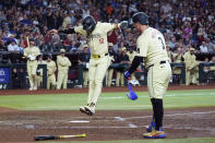 Arizona Diamondbacks' Lourdes Gurriel Jr. (12) scores on a wild pitch as Joc Pederson (3) watches on during the fifth inning of the team's baseball game against the Chicago Cubs on Tuesday, April 16, 2024, in Phoenix. (AP Photo/Ross D. Franklin)